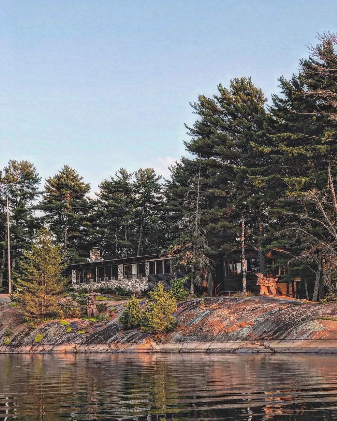 Shebanoning Lodge nestled among pine trees on pink granite shoreline, viewed from Georgian Bay